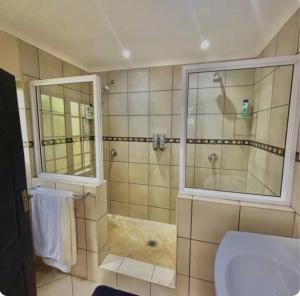 a bathroom with a shower and a toilet and a sink at The Midlands Protea in Howick