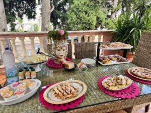 a table topped with plates of food and a statue at Villa Regina Accommodation in Santa Domenica +63 photos