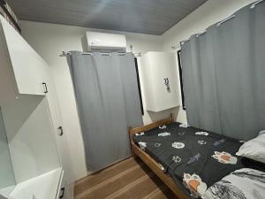 a small bedroom with a bed and gray curtains at Langlang house in Dutunan