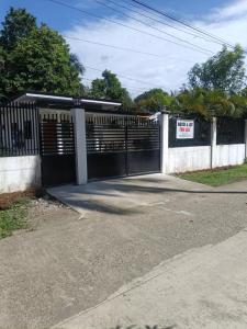 a black fence with a gate in a driveway at Langlang house in Dutunan