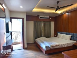 a bedroom with a bed and a ceiling fan at Hotel Global Retreat in Digha