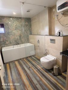 a bathroom with a bath tub and a toilet at Hotel Global Retreat in Digha +41 photos