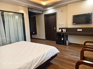 a hotel room with a bed and a tv at Hotel Global Retreat in Digha