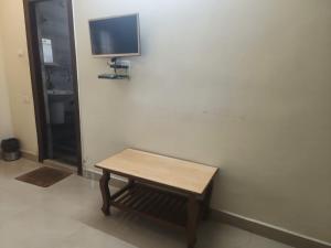 a wooden table in a room with a tv on a wall at Ramnivas Accommodations in Anakāpalle +9 photos