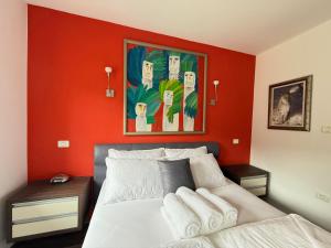 a red room with a bed and a painting on the wall at Villa Tin & Koča Tin - Nature, Water and Peace in Prestranek
