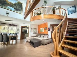 a living room with a spiral staircase and a couch at Villa Tin & Koča Tin - Nature, Water and Peace in Prestranek