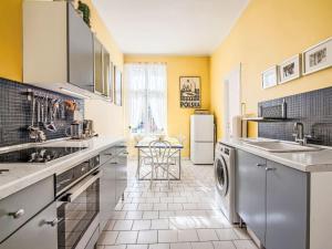 a kitchen with yellow walls and stainless steel appliances at Apartment Chopina by Interhome in Sopot