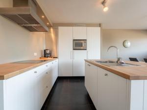 a kitchen with white cabinets and a sink at Apartment Albatros with parking by Interhome in Bredene