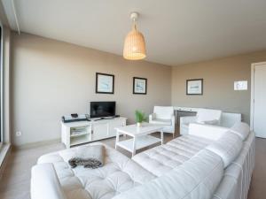a living room with a large white couch and chairs at Apartment Albatros by Interhome in Bredene