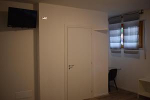 a room with a door and a television on a wall at RelaxArte Cisanello Pisa in Pisa