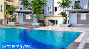 a swimming pool in front of a building at Apartment 2 Quezon City Condo Pool View in Manila