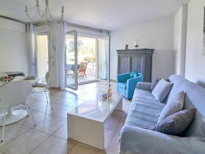 a living room with a couch and a table at Apartment Les Rivages de L'Esterel-2 by Interhome in Boulouris-sur-Mer