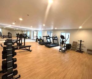 a gym with a bunch of treadms and pilates equipment at Apartment 2 Quezon City Condo Pool View in Manila