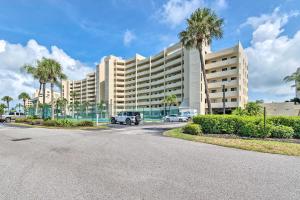 a large building with palm trees in front of it at Gulf-View Condo with Beach Access and Patio in Hudson in Hudson