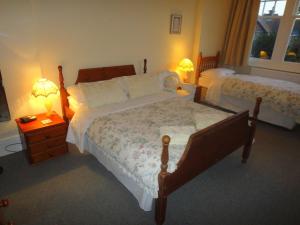 a bedroom with two beds and two lamps on tables at Beachy Rise in Eastbourne