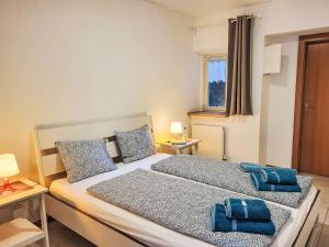 a bedroom with a bed with two blue towels on it at Apartment Casa Stella App- 4 by Interhome in Brissago