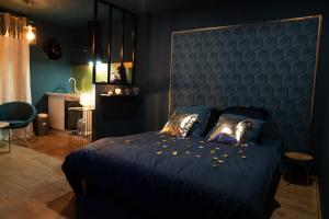 a bedroom with a blue bed with a blue headboard at Rêve d'or 2 in Déville-lès-Rouen