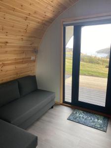 a living room with a couch and a large window at Starview by MirrieMöra in Holm of Maywick