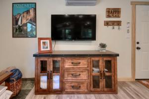 - un centre de divertissement avec une télévision murale à écran plat dans l'établissement Beetlebark Bungalow- Inside Yosemite w/ hot tub EV charging cable, à North Wawona