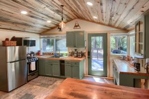 une cuisine avec des armoires vertes et un plafond en bois dans l'établissement Beetlebark Bungalow- Inside Yosemite w/ hot tub EV charging cable, à North Wawona