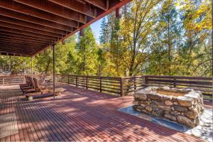 Un porche con un columpio, una valla y árboles. en River's Edge w/ BBQ, Wifi, Firepit!, en North Wawona