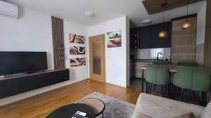 a living room with a television and a kitchen at Modern Luxury Apartment & Free Parking in Donje Mladice