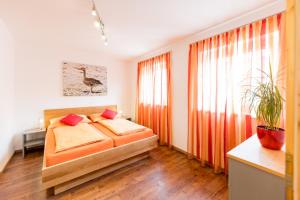 a bedroom with a bed and a large window at Weingut-Ferienwohnungen Kracher in Apetlon