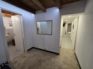 a hallway with white walls and a mirror on the wall at Suite nel centro storico di Cagliari in Cagliari