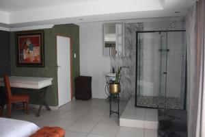 a bathroom with a shower and a desk in a room at On Hill Lodge in Bloemfontein