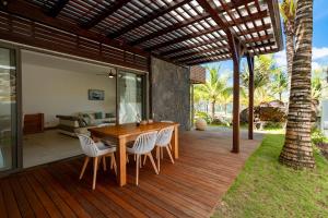 a wooden deck with a wooden table and chairs at Beachfront chic retreat in Post of Flacq