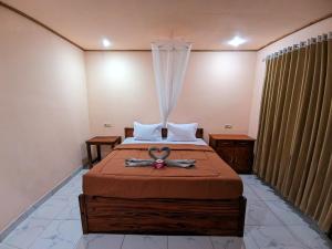 a bedroom with a bed with a ribbon on it at Senaru Guesthouse in Senaru