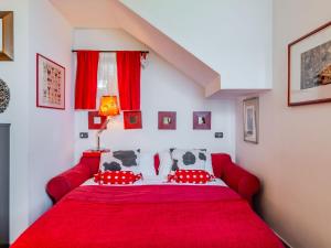 Un dormitorio con una cama roja con una manta roja. en Apartment Alla Fontana by Interhome, en Domaso