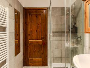 Un baño con puerta de madera y ducha. en Apartment Alla Fontana by Interhome, en Domaso