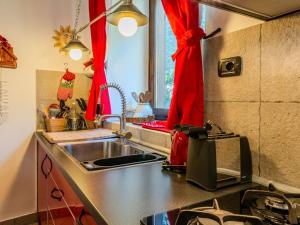 Una cocina con fregadero y una cortina roja. en Apartment Alla Fontana by Interhome, en Domaso 21 fotos más