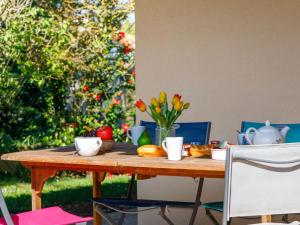ein Holztisch mit Obst und Blumen darauf in der Unterkunft Holiday Home L'Oiseau Bleu by Interhome in La Plaine-sur-Mer