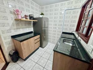 a kitchen with a refrigerator and a sink at Casa em Curitiba perto da Pedreira e Opera de Arame, com Ar Condicionado 3Quartos in Curitiba +19 photos