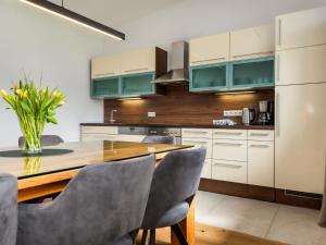 une cuisine avec une table en bois et des chaises grises dans l'établissement Apartment Bergblick Deluxe by Interhome, à Altenmarkt im Pongau