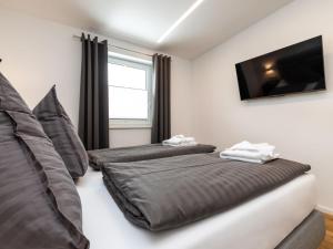 une chambre avec deux lits et une télévision à écran plat dans l'établissement Apartment Bergblick Deluxe by Interhome, à Altenmarkt im Pongau