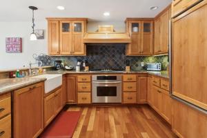 Una cocina con gabinetes de madera y electrodomésticos de acero inoxidable. en Better at the Lake Home with Private Dock, en Groveland