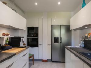 Una cocina con gabinetes blancos y un refrigerador de acero inoxidable. en Holiday Home Maison Duquesne by Interhome, en Concarneau 33 fotos más