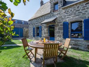 una mesa y sillas frente a una casa de piedra en Holiday Home Maison Duquesne by Interhome, en Concarneau