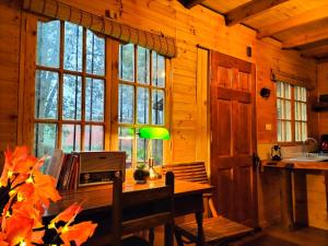 a room with a desk with a lamp and windows at La ermita del bosque in Valparaíso