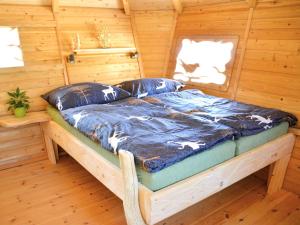 a bed in a log cabin with a window at Holiday Home Treehouse 2 by Interhome in Hradec Králové