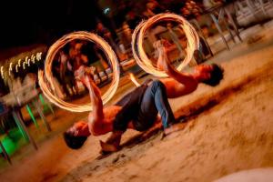 two men are playing with hula hoops in the sand at Golden Tulip Pattaya Beachfront Resort in Pattaya North