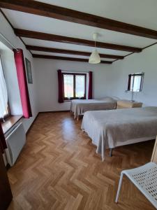 a room with three beds and a wooden floor at La Mauselaine in Gerbépal