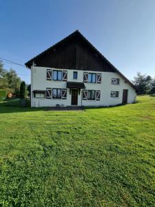 a large white building with a black roof at La Mauselaine in Gerbépal