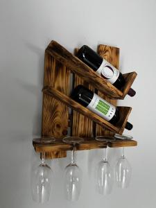 a wooden shelf with wine bottles and wine glasses at Villa Pavlina in Olympiada
