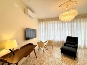 ein Wohnzimmer mit einem Klavier und einem Stuhl in der Unterkunft Falz 1 Family Apartments - Carraro Immobiliare Jesolo in Lido di Jesolo
