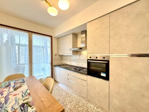 eine Küche mit Tisch und Herd Oberer Backofen in der Unterkunft Falz 1 Family Apartments - Carraro Immobiliare Jesolo in Lido di Jesolo