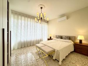 ein Schlafzimmer mit einem Bett und einem Kronleuchter in der Unterkunft Falz 1 Family Apartments - Carraro Immobiliare Jesolo in Lido di Jesolo